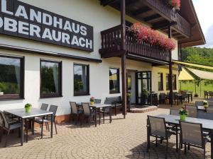 a restaurant with tables and chairs in front of a building at Landhaus Oberaurach in Oberaurach