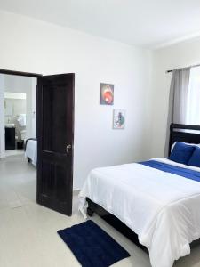 a bedroom with a large bed with a blue rug at The White Rock Hotel B&B in Los Conucos