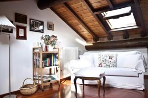 - un salon avec un canapé blanc et une étagère à livres dans l'établissement Appartamento Relax Lago di Como, à Bellano