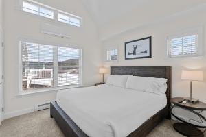 1 dormitorio blanco con 1 cama grande y 2 ventanas en Owl's Nest Resort, en Thornton