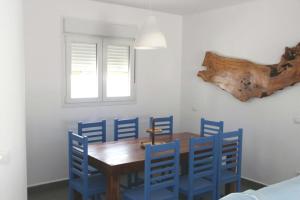 a dining room with a wooden table and blue chairs at LIOMA VELLA 1 in Peniscola