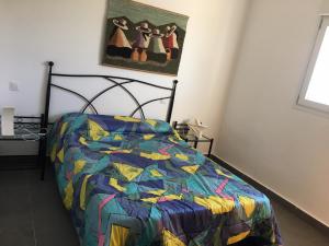 a bedroom with a bed with a colorful comforter at LIOMA VELLA 1 in Peniscola