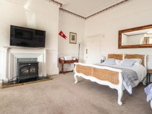 a bedroom with a bed and a fireplace at Ismay Dining Room Suite - Titanic Interest in Crosby