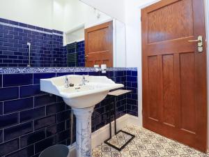 baño con lavabo blanco y azulejos azules en Ismay Dining Room Suite - Titanic Interest, en Crosby