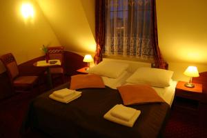 een hotelkamer met een bed met handdoeken erop bij Hotel Karolinka in Gogolin