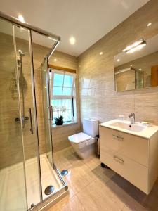 een badkamer met een douche, een wastafel en een toilet bij PARADISE ON THE BEACH in Albufeira