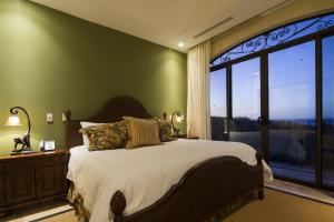 una camera con un grande letto e una grande finestra di Jobo 7 Luxury Penthouse - Reserva Conchal a Playa Conchal
