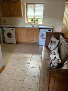 a kitchen with a couch and a washing machine at The Annex, Coed Y Gaer in Llansilin