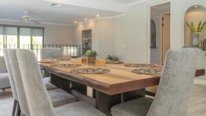 una sala da pranzo con tavolo e sedie in legno di Bougainvillea 2102 Luxury Apartment - Reserva Conchal a Playa Conchal