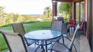 un tavolo e sedie su un portico con griglia di Bougainvillea 2102 Luxury Apartment - Reserva Conchal a Playa Conchal