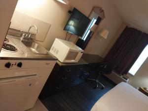 a small kitchen with a sink and a microwave at Fairway Inn La Porte in La Porte