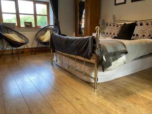 a bedroom with a bed and chairs in a room at The Annex, Coed Y Gaer in Llansilin