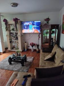 a living room with a couch and a flat screen tv at Nora's HomeStay Laureles in Medellín
