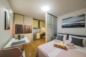 Habitación pequeña con cama y mesa. en Paeninsula Studio Apartment, en Vranjic