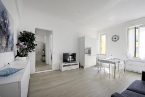 Guest House Romano في روما: غرفة معيشة بيضاء مع طاولة وتلفزيون
