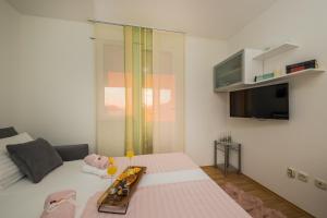 Un dormitorio con una cama con una bandeja de comida. en Paeninsula Studio Apartment, en Vranjic