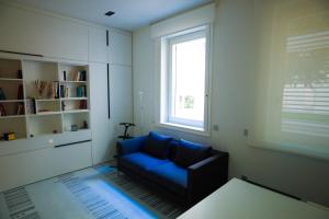 a living room with a blue couch and a window at Stylish Mini in the Heart of Milano in Milan