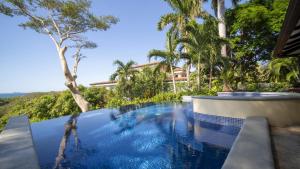 una piscina en un complejo con palmeras en Villa Zindagi Luxury Villa Private Pool - Reserva Conchal en Brasilito