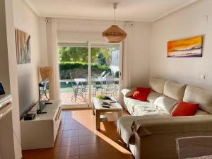 a living room with a couch and a table and a television at Maison Illeta Golf Bonalba in Mutxamel