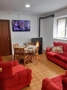 a living room with a table and a fireplace at VUT El Refugio in Villablino