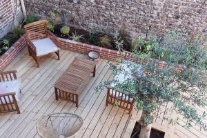 un patio avec deux bancs, une table et des chaises dans l'établissement Très bel appartement au pied du port l'Albâtre, à Saint-Valery-en-Caux