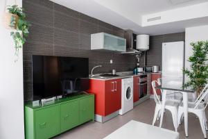 cocina con armarios rojos y verdes y lavadora en Apartamentos Vernia, en Xàtiva