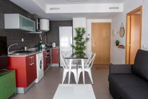 cocina y sala de estar con mesa y sofá en Apartamentos Vernia, en Xàtiva