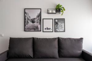 a couch in a living room with three pictures on the wall at Apartamentos Vernia in Xàtiva