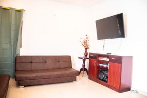 a living room with a couch and a flat screen tv at CABAÑA BELÉN in Santa Marta