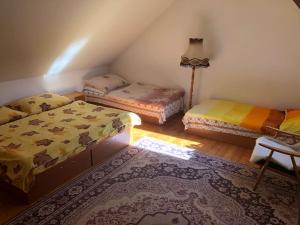 Cette chambre comprend 2 lits, une table et un tapis. dans l'établissement 3 room Apartment, Kvačany pri LM, à Kvačany