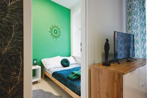 1 dormitorio con cama y pared verde en Apartament na Starym Mieście, en Gliwice