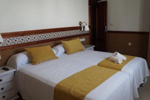 a bedroom with a large bed with towels on it at Hostal La Conileña in Conil de la Frontera