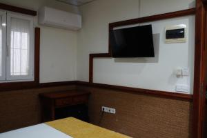 a room with a flat screen tv on a wall at Hostal La Conileña in Conil de la Frontera +41 photos