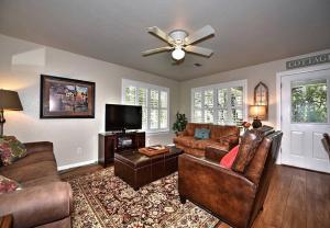 sala de estar con muebles de cuero y ventilador de techo en Comal Cottages River 403C, en New Braunfels