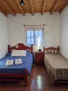 1 dormitorio con 2 camas y ventana en Lo de Valentino Cabaña en Cachí