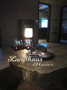 two glasses of wine on a table with a sign that reads landahucahaven at Exklusives Landhaus Haar, Emsland in Emsbüren