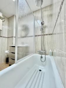 a white bath tub in a bathroom with a shower at Ivory Suites in Málaga