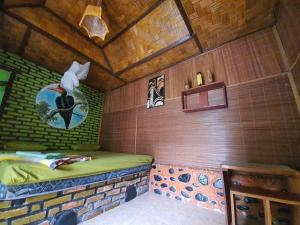 a small room with a bed in a cabin at Lucky Bamboo'Bungalows and Orangutan Jungle Trekking Tours in Bukit Lawang