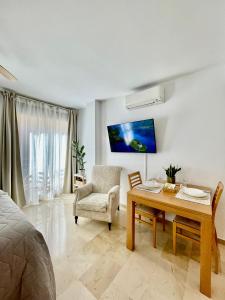 a living room with a table and a chair at Ivory Suites in Málaga