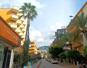 uma rua da cidade com palmeiras e edifícios em Very close to Cleopatra beach. em Alanya