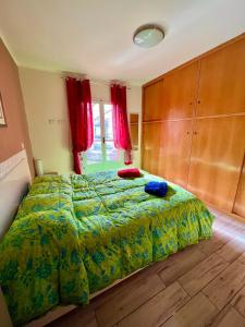a bedroom with a large bed with a green comforter at Casetta Levà in Arma di Taggia