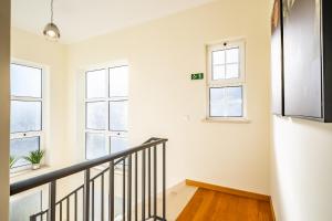 - un escalier dans une chambre blanche dotée de fenêtres dans l'établissement Gaula Residence by Madeira Sun Travel, à Santa Cruz