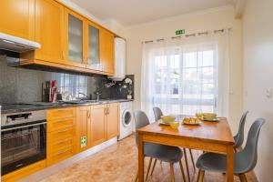 - une cuisine avec une table et des chaises en bois dans l'établissement Gaula Residence by Madeira Sun Travel, à Santa Cruz