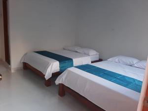 dos camas sentadas una al lado de la otra en una habitación en Hotel Distracción Guajira, en Fonseca