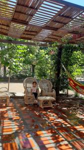 una mujer sentada en una silla bajo una pérgola en Hotel Distracción Guajira, en Fonseca