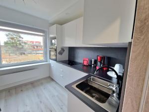 a small kitchen with a sink and a window at MilaAna in Visaginas