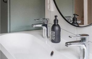 un lavandino in bagno con una bottiglia di sapone di Pet Friendly Apartment In Vallda With Wifi a Vallda