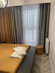 1 dormitorio con 1 cama y una ventana con cortinas en Apartament Elisabeth BLUE I, en Pogórze