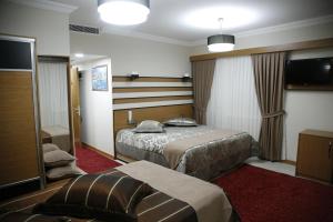 a hotel room with two beds and a television at Quars Garden Hotel in Koçyazı