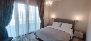 a bedroom with a bed and a large window at Η πέρλα της λίμνης/ The lake's pearl in Ioannina